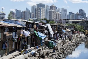 TOPSHOT - People living in a settlement walk about, as the skyline of Manila's financial district is seen in the background, on August 17, 2017.  The Philippine economy grew by 6.5 percent in the three months to June, likely one of the fastest in Asia, the government said on August 17, defying concerns over President Rodrigo Duterte's unconventional leadership. / AFP PHOTO / Noel CELIS        (Photo credit should read NOEL CELIS/AFP/Getty Images)