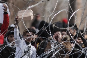 epa08264366 Refugees and migrants gather on the Turkish side of the closed Kastanies border crossing, on the borderline between Greece and Turkey, near the Evros River, in an attempt to cross into Greece, 02 March 2020. Thousands of refugees and migrants are gathering on the Turkish side of the border with Greece with the intent to cross into the European Union following the Turkish government's decision to loosen controls on migrant flows after the death of 33 Turkish soldiers killed in an attack in Idlib, Syria on 27 February. EPA/DIMITRIS TOSIDIS